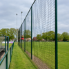 Ballenvangernet voetbal 7 Ballenvangernet voor voetbal langs een voetbalveld met hoge staanders en zwart net